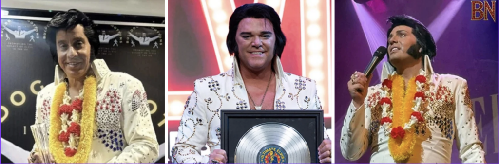 Elvis tribute artist in a jeweled white jumpsuit with a yellow garland, holding a trophy on stage.